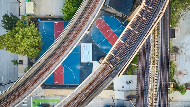 Image of Empty train track, railroad transit, transportation bridges above basketball courts aerial, Chicago IL