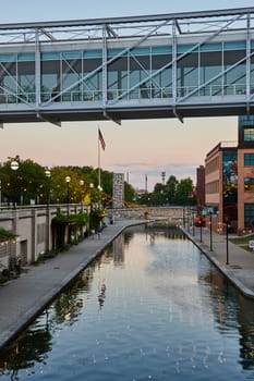 Serene Evening at Indianapolis, 2023 - Modern Pedestrian Bridge Crossing Reflective Canal, Flanked by Urban Buildings