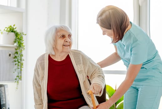 Nurse Assists Elderly Woman In Doctor'S Office