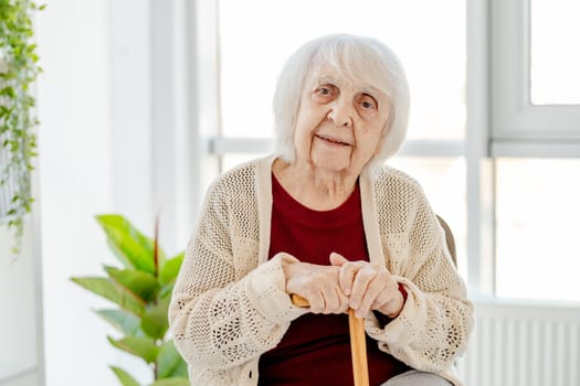 Smiling Elderly Woman Of 80 Years Sits In A Bright Room