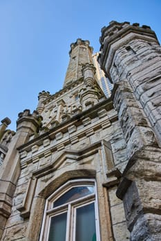 Image of Upward view of old Chicago water tower with historic architecture building on blue sky day