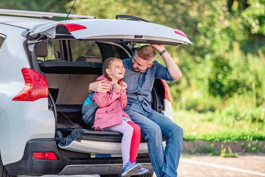 Dad Picks Up His Little Daughter From School In His Car, They Play Around And Sit In The Trunk Laughing, Giving Each Other High Fives