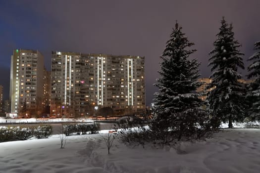 Winter cityscape with multi-storey residential buildings and snow covered fir trees in Moscow, Russia