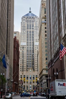 Image of Downtown Chicago Illinois street with patriotic American flag on building and city skyscrapers
