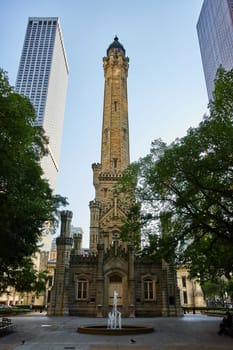 Image of Old Chicago water tower with historic architecture and water fountain and trees in front of building