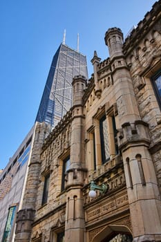 Image of Ominous Chicago Water Works historic building with castle architecture with skyscraper and blue sky