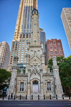 Image of Cheerful castle in city, Chicago original, historic water tower on summer day with blue sky
