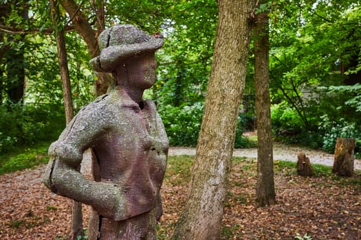Textured sculpture of reflective figure in serene woodland setting at Art Center, Indianapolis, Indiana, 2023