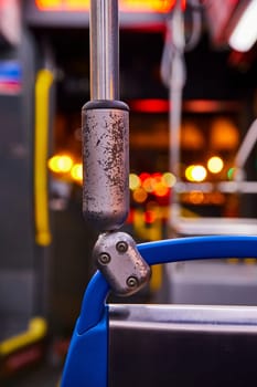 Image of Railing, handlebar in bus at night close up, colorful blurred city lights, transportation, transit
