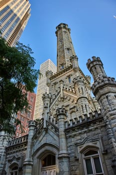 Image of Old, historic, original Chicago city water tower building with castle architecture under blue sky