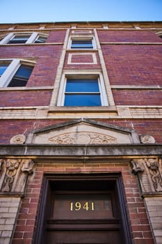 Image of 1941 old brick house, apartment building with windows above cool architecture of door, mortgage
