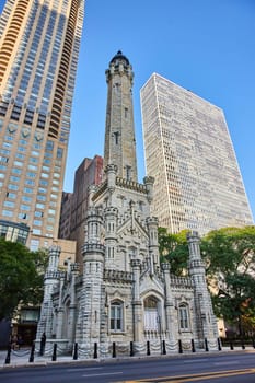 Image of Bright castle architecture of old, historic, original Chicago water tower amid city skyscrapers