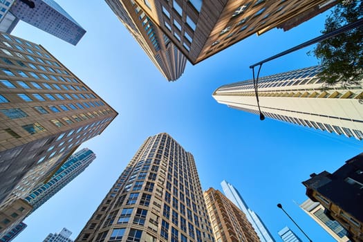 Image of Upward view of Chicago skyscrapers stretching toward clear blue sky, architecture, travel, tourism