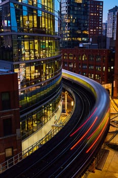 Twilight Rush Hour in Chicago 2023 - Blurred Motion of Train on Elevated Tracks Amidst Historic and Modern Architecture