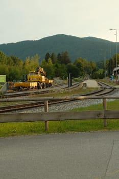 Vertical shot of a yellow rail excavator in Gmund am Tegernsee, Bavaria, Germany