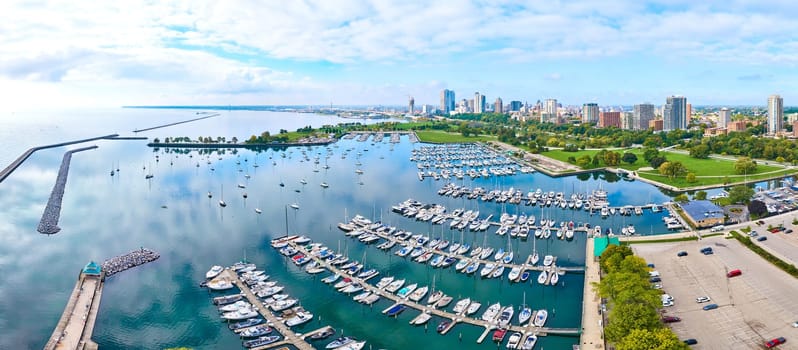 Aerial view of bustling Milwaukee marina with docked boats, serene Lake Michigan and vibrant city skyline