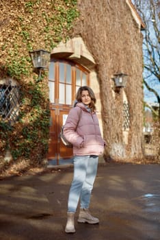 Young beautiful pretty tourist girl in warm hat and coat with backpack walking at cold autumn in Europe city enjoying her travel in Zurich Switzerland. Outdoor portrait of young tourist woman enjoying sightseeing