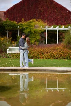 lovely young couple kissing outdoors in autumn. Loving couple walking in nature. Autumn mood. Happy man and woman hugging and kissing in autumn. Love. Fashionable couple outdoors. Fashion, people and lifestyle. Stylish couple in autumn outfit.