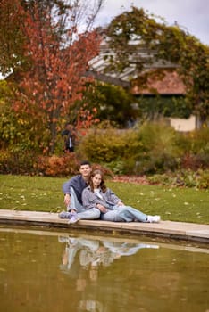 lovely young couple kissing outdoors in autumn. Loving couple walking in nature. Autumn mood. Happy man and woman hugging and kissing in autumn. Love. Fashionable couple outdoors. Fashion, people and lifestyle. Stylish couple in autumn outfit.