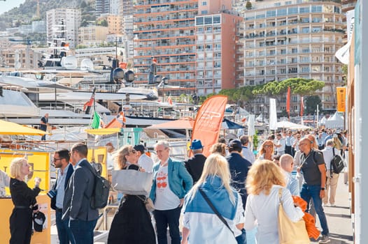 Monaco, Monte Carlo, 28 September 2022 - a lot of people, clients and yacht brokers look at the mega yachts presented, discuss the novelties of the boating industry at the famous motorboat exhibition. High quality photo