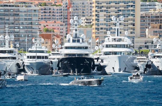 Monaco, Monte Carlo, 28 September 2022 - a motor boat with guests of yacht brokers departs from the shore in the largest fair exhibition in the world yacht show MYS, port Hercules, rich clients, sunny. High quality photo