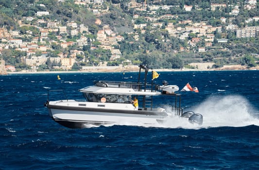 Monaco, Monte Carlo, 28 September 2022 - a motor boat with guests of yacht brokers departs from the shore in the largest fair exhibition in the world yacht show MYS, port Hercules, rich clients, sunny. High quality photo