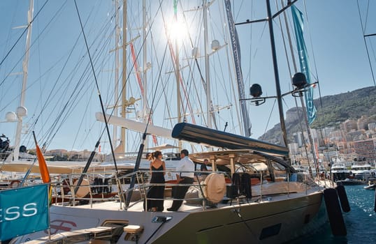 Monaco, Monte Carlo, 28 September 2022 - Invited wealthy clients inspect megayachts at the largest fair exhibition in the world yacht show MYS, port Hercules, yacht brokers, sunny weather. High quality photo