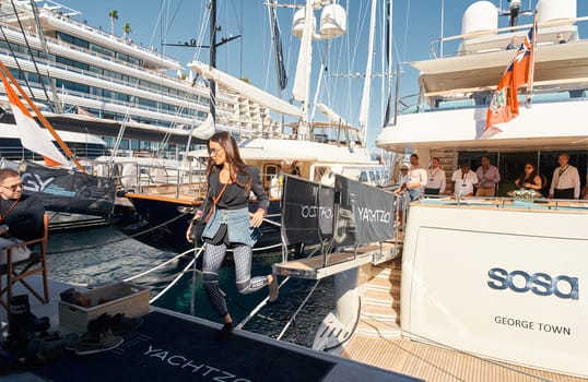 Monaco, Monte Carlo, 28 September 2022 - Invited wealthy clients inspect megayachts at the largest fair exhibition in the world yacht show MYS, port Hercules, yacht brokers, sunny weather. High quality photo