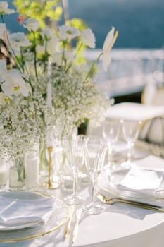 Served festive table with white bouquet of flowers. High quality photo