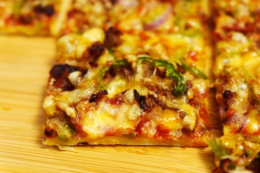 St. Louis-Style Pizza on a plate, cut into squares, on a wooden background.