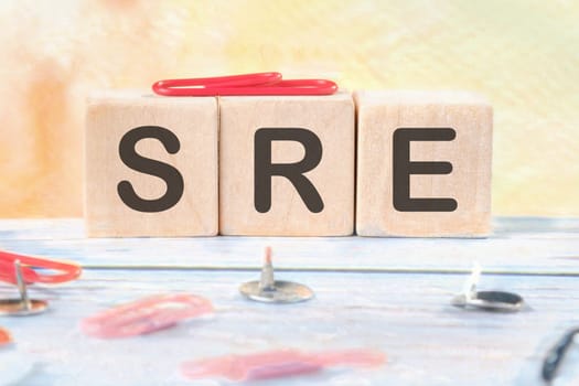 SRE. Site Reliability Engineering signs on wooden cubes on a light background