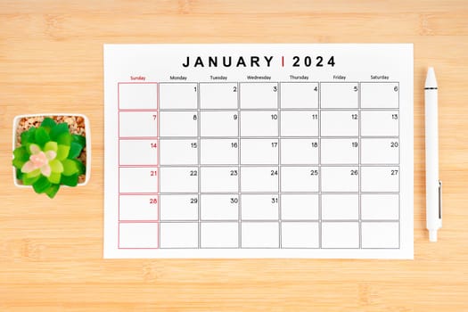 January 2024 calendar page and houseplant on wooden background with empty space.