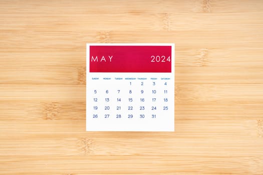 May 2024 calendar page on wooden background with empty space.