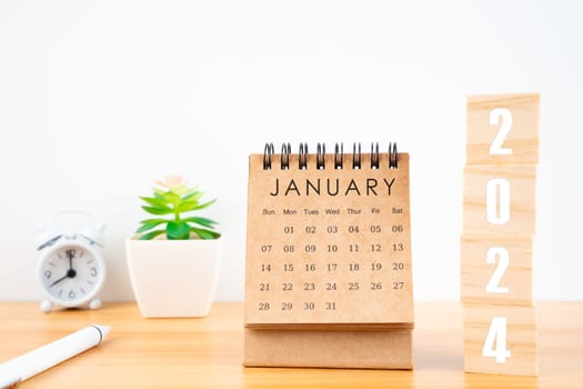 January 2024 desk calendar with wooden cubes show 2024 number on worktable.