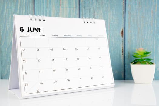 July 2024 calendar on the white table with blue wooden background.