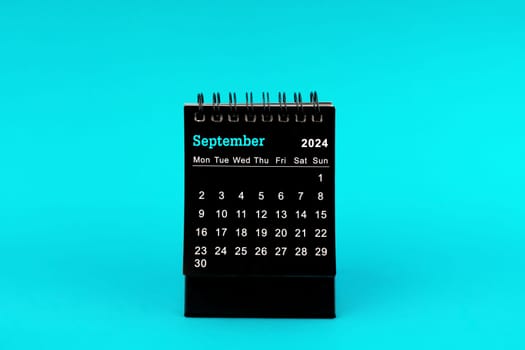 Black Calendar for September 2024. Desktop calendar on a green color background.