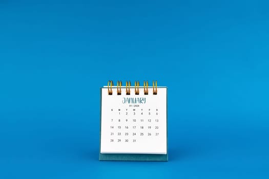 January 2024 mini desk calendar on blue color background.
