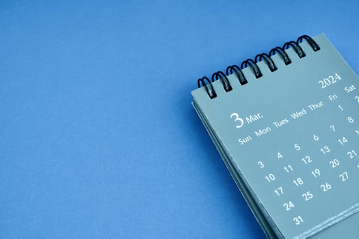 March 2024 desk calendar on blue color background. Copy space.