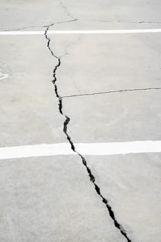 A crack runs across a cement floor on street.