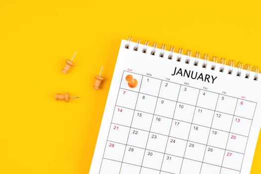 January 2024 Monthly desk calendar for 2024 year with pin on yellow background.
