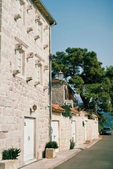 Ancient stone house by the road with shutter holders near the windows. High quality photo