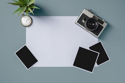 Vintage photo camera and empty photo frames on blue background. Travel moment concept