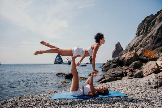 Woman sea yoga. Back view of free calm happy satisfied woman with long hair standing on top rock with yoga position against of sky by the sea. Healthy lifestyle outdoors in nature, fitness concept.