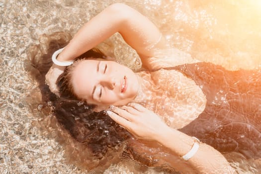 Woman travel sea. Young Happy woman in a long red dress posing on a beach near the sea on background of volcanic rocks, like in Iceland, sharing travel adventure journey