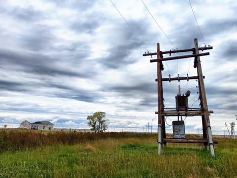 Old power poles and the sky with clouds in the background. Electric lines, towers, wires in landscape