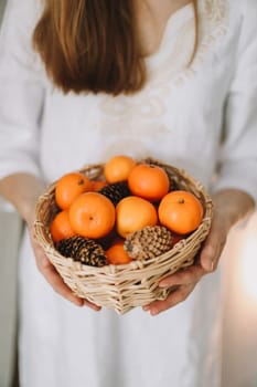 Woman hand holds mandarins in a string bag. New Year and Christmas concept