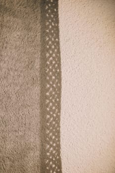 Lace curtains and their shadows. Sunlight falling on wall and creating shadow from curtains background