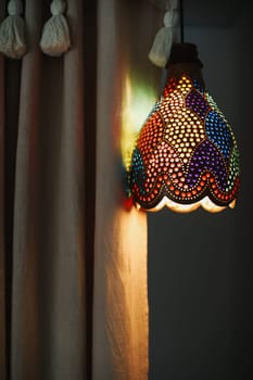 Decorative lamp shade with warm light next to a bookshelf. High quality photo