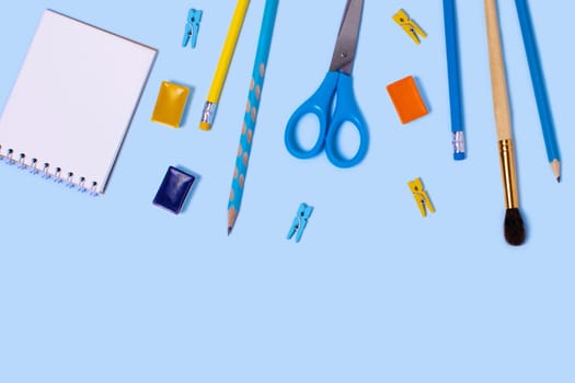 School supplies on blue background. Back to school flat lay picture.