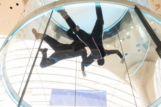 Indoor. Man fly in wind tunnel. Indoor skydiving. New fly sport. High quality photo